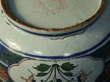 a blue and white bowl sitting on a table with a spoon