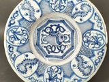 un gros plan d'une assiette bleue et blanche posée sur une table