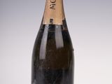 an old bottle of champagne sitting on top of a white table