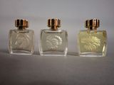 three bottles of perfume sitting next to each other on a table