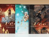 trois livres sont alignés sur une table à fond blanc