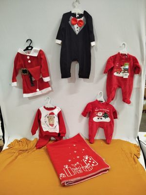 beaucoup de vêtements pour bébés exposés sur un lit