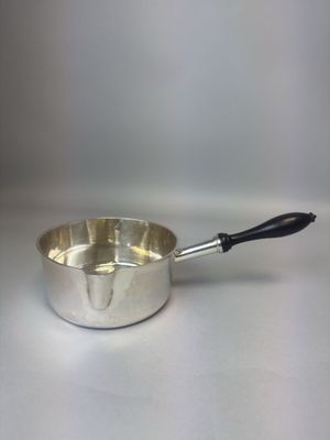 casserole argentée avec une poignée noire sur un fond blanc