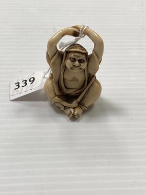 un gros plan d'une figurine de singe posée sur une surface blanche