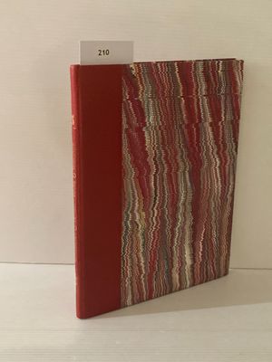 un livre rouge à la couverture rayée posé sur une table blanche