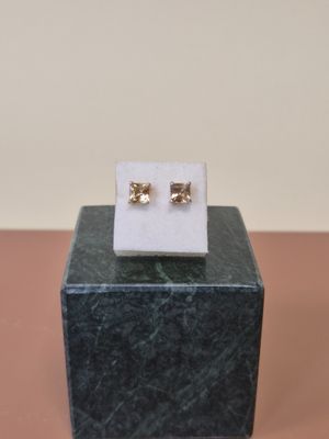 une paire de boucles d'oreilles posée sur un bloc de marbre