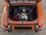 a small orange car with its hood open and the engine in it ' s trunk