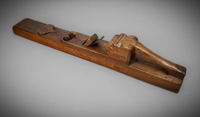 an old wooden plane with a wooden handle on a gray background
