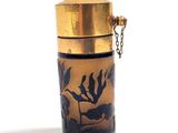 a glass container with a gold lid and a chain around it
