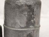 two metal containers sitting next to each other on a white surface
