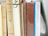 several books are stacked on top of each other on a shelf