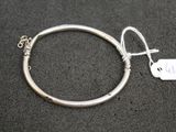 un gros plan d'un bracelet en argent auquel est attachée une étiquette