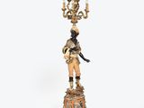 a statue of a man standing on a pedestal with a chandelier