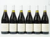 six bouteilles de vin sont alignées sur une surface blanche