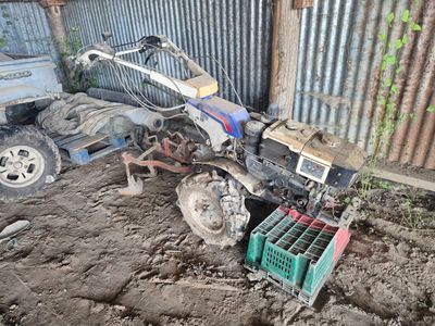 un petit tracteur qui est à l'arrêt dans la terre