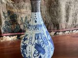 a blue and white vase sitting on a wooden table