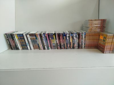 a lot of dvds on a shelf next to each other