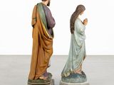 two figurines of jesus and mary on pedestals in a room