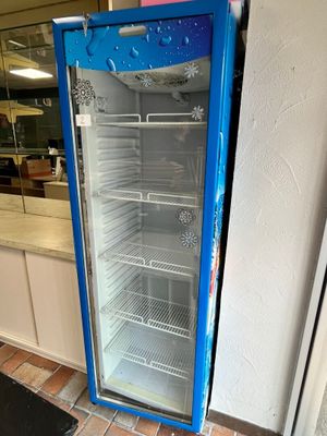 un réfrigérateur bleu posé dans un coin d'une pièce
