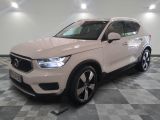 Le SUV Volvo blanc est garé dans une pièce dont le sol est en damier.