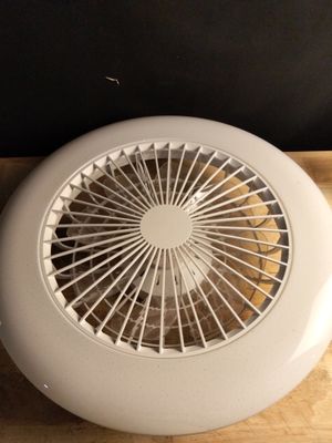 un éventail blanc posé sur une table en bois