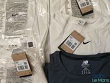 two packages of nike shirts on a bed next to each other