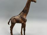 statue d'une girafe debout sur une surface blanche, avec un arrière-plan gris