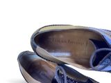 pair of women ' s blue shoes with bows on them on a white surface