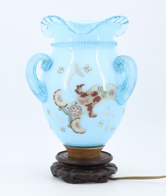 a blue vase with a handle on a wooden stand