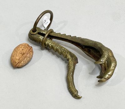 an image of a cork opener with a walnut in the background