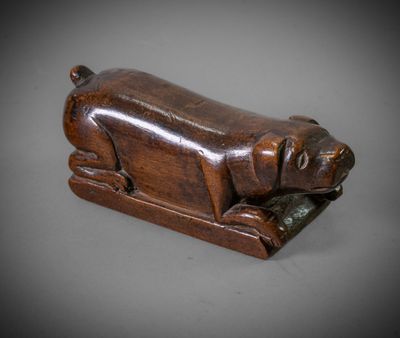 an old wooden sculpture of a dog laying down on its side