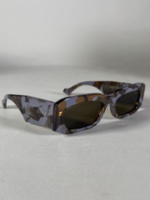 Il s'agit de deux paires de lunettes de soleil posées sur une surface blanche.