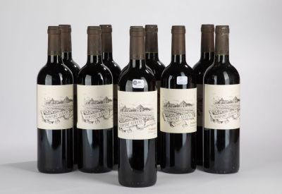 six bouteilles de vin sont alignées sur une surface blanche
