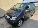 une photo d'une petite voiture noire garée sur le bord de la route