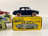several toy cars are lined up on top of boxes on a white surface