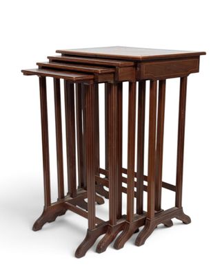 un ensemble de trois tables gigognes en bois sur fond blanc
