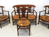four chairs and a table in a room with a white wall