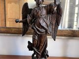 a statue of an angel holding a sword and a shield on a table