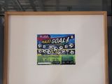 a picture of a picture of a soccer game in a glass case