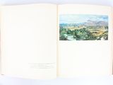 an open book with a picture of a landscape on it