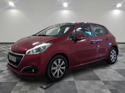 une voiture rouge est garée dans une pièce au sol en damier