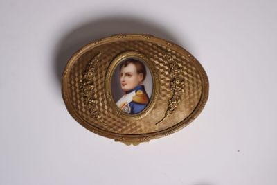 une boîte dorée sur laquelle figure l'image d'un homme