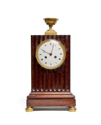 a wooden clock that is on a stand with a white background