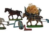 plusieurs figurines représentant des chevaux tirant une charrette chargée de foin
