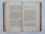 an open book on a white table with writing on it