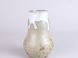 a small vase that has a white and brown design on it