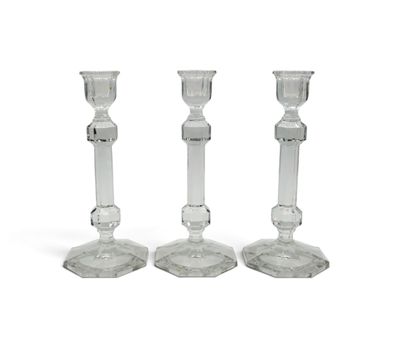 trois bougeoirs en verre transparent posés les uns à côté des autres sur une surface blanche