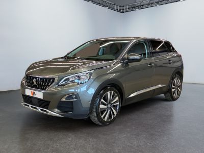 La voiture grise est garée dans une grande pièce aux murs blancs.