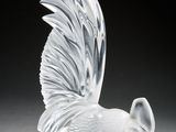 figurine en cristal représentant un oiseau sur un socle, sur fond noir