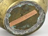 a gold vase with a label on it